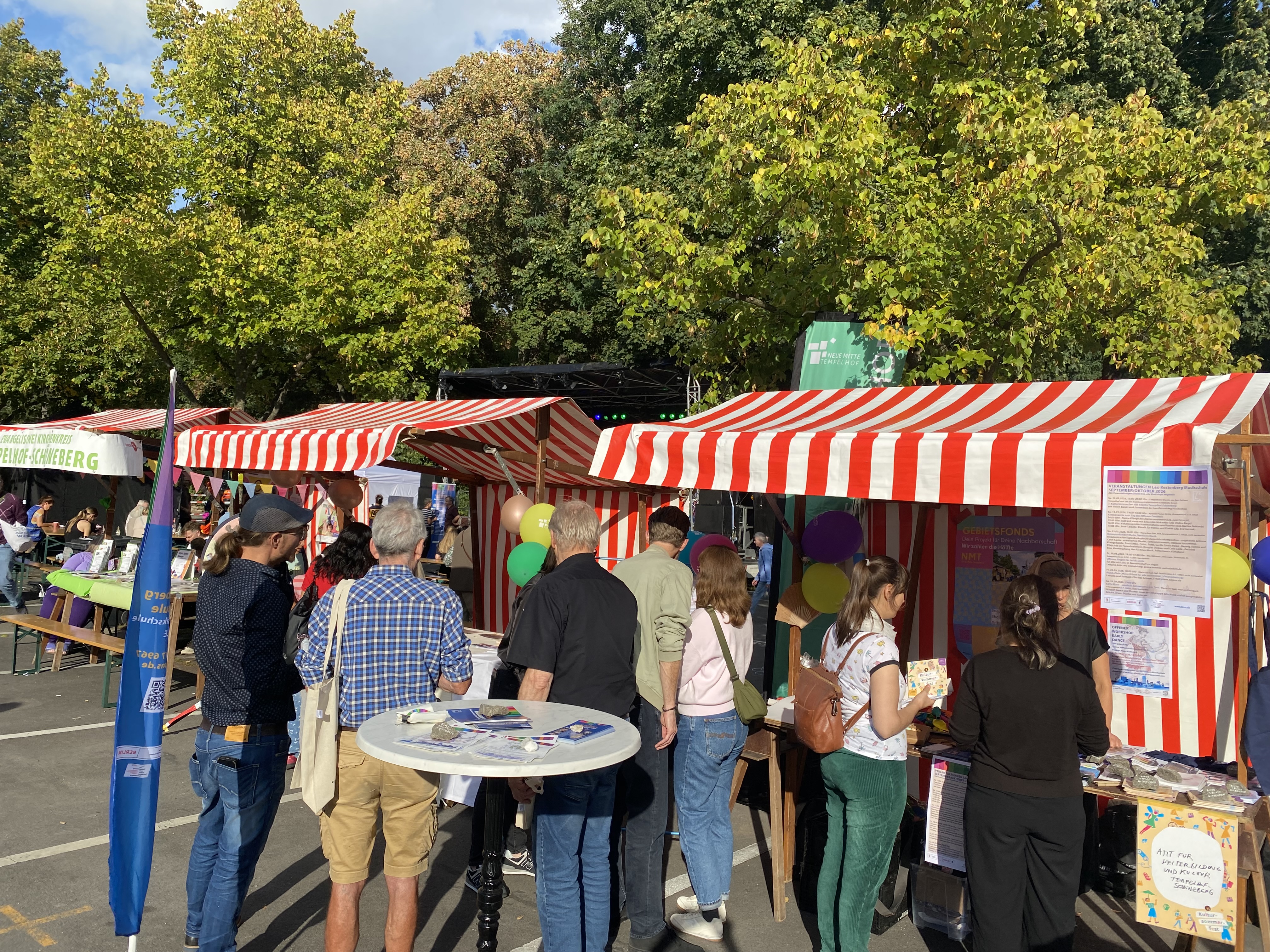 Bunter Marktstand mit Menschen davor