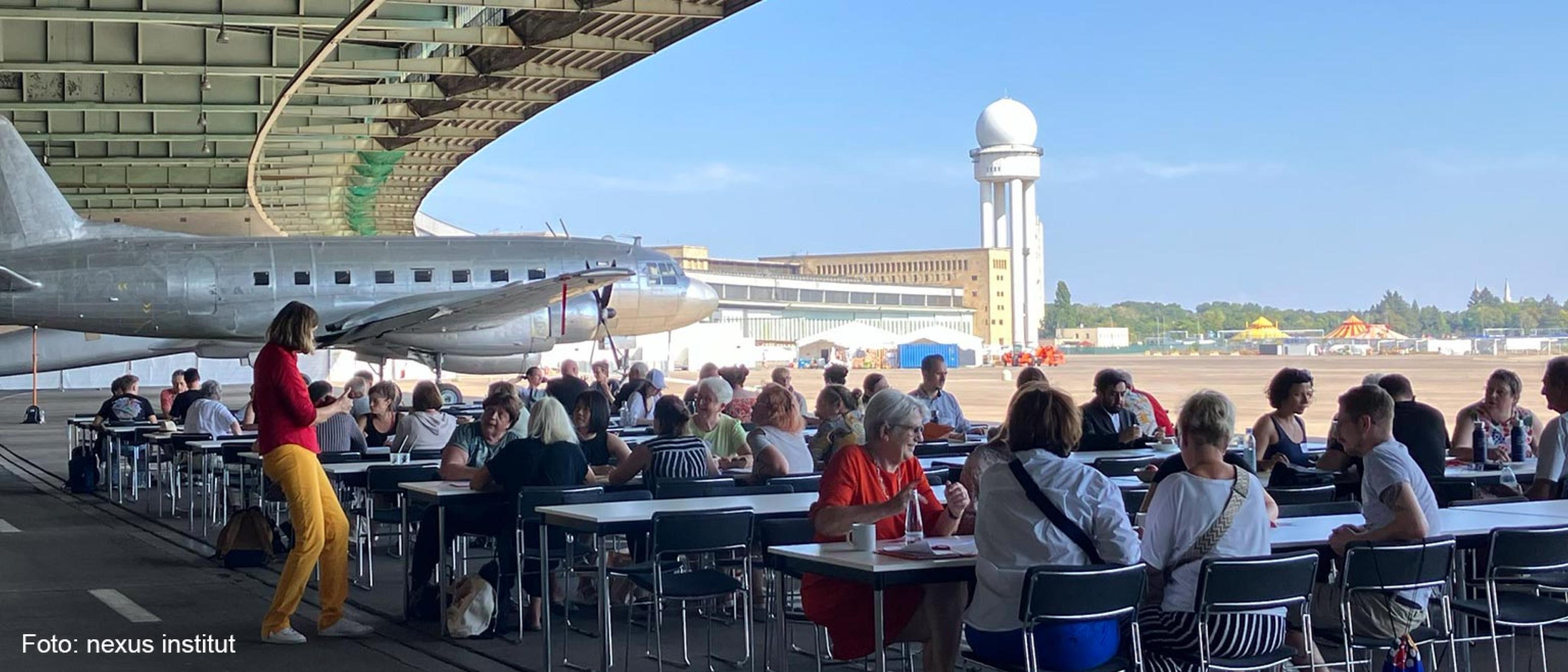 Teilnehmende an Arbeitstische im Hangar des Flughafengebäudes Tempelhof  